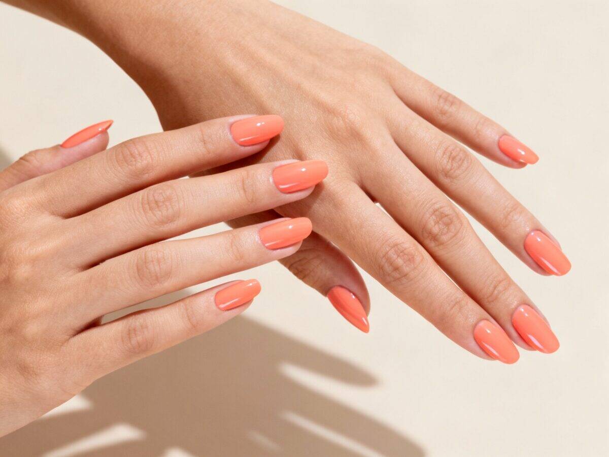 Unhas pintadas com esmalte Peach Fizz, tom pêssego luminoso e delicado, refletindo o brilho e a suavidade do verão 2025.