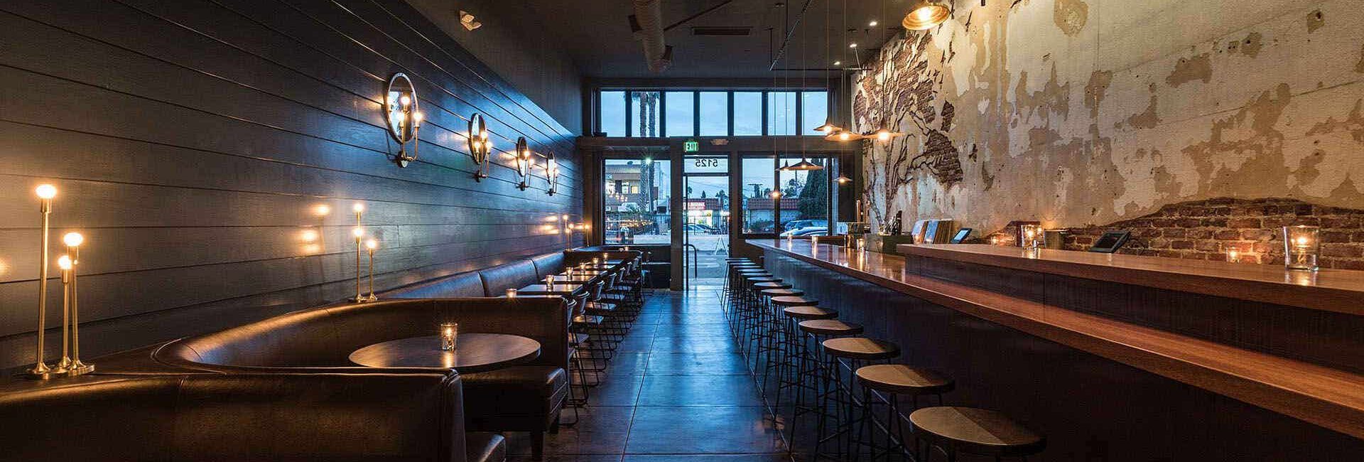 Tabula Rasa Bar's cozy interior with wine bottles lining the wall