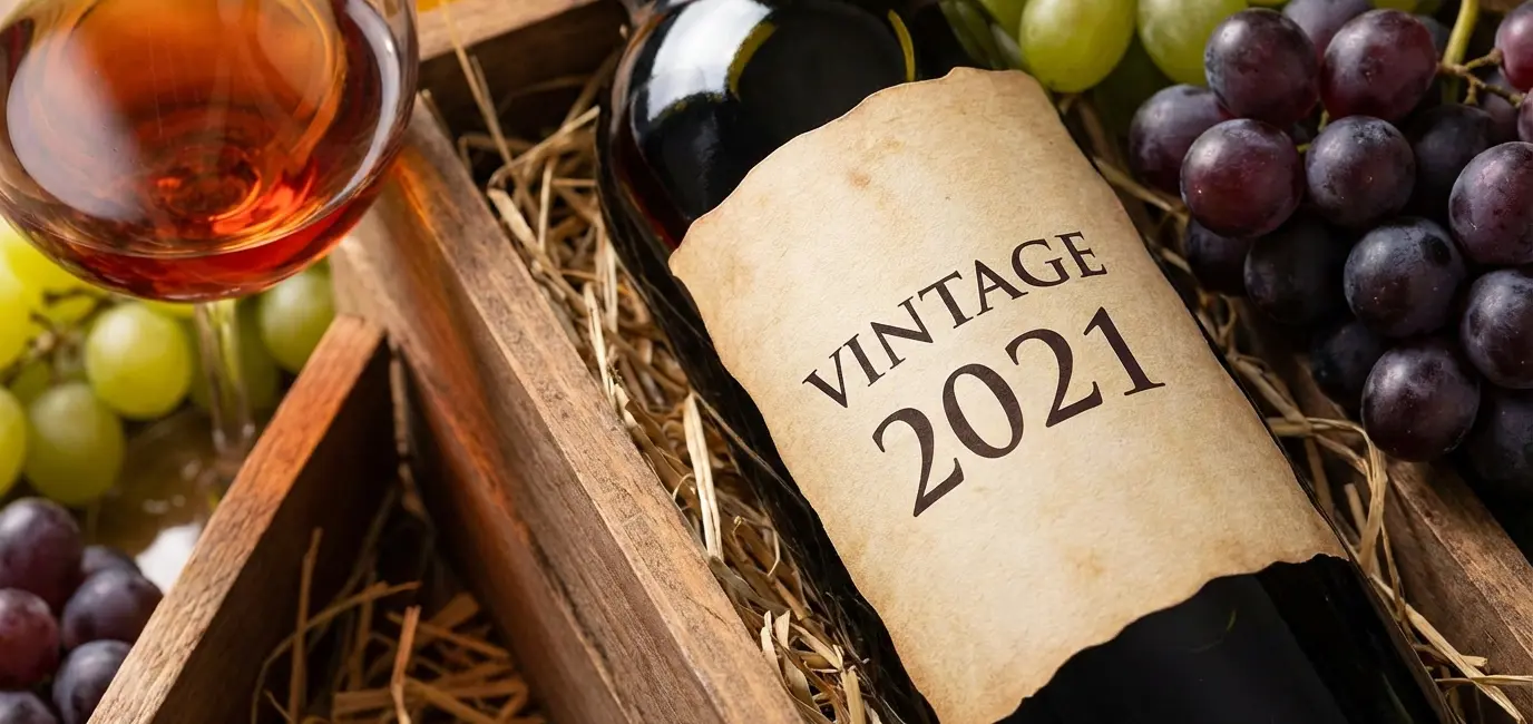 wine label vintage year detail with bottle grapes and wine crate warm amber tones