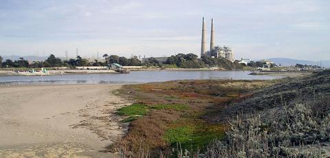 Moss Landing north harbor from Jetty Road, at low tide, with powerplant stacks in the distance