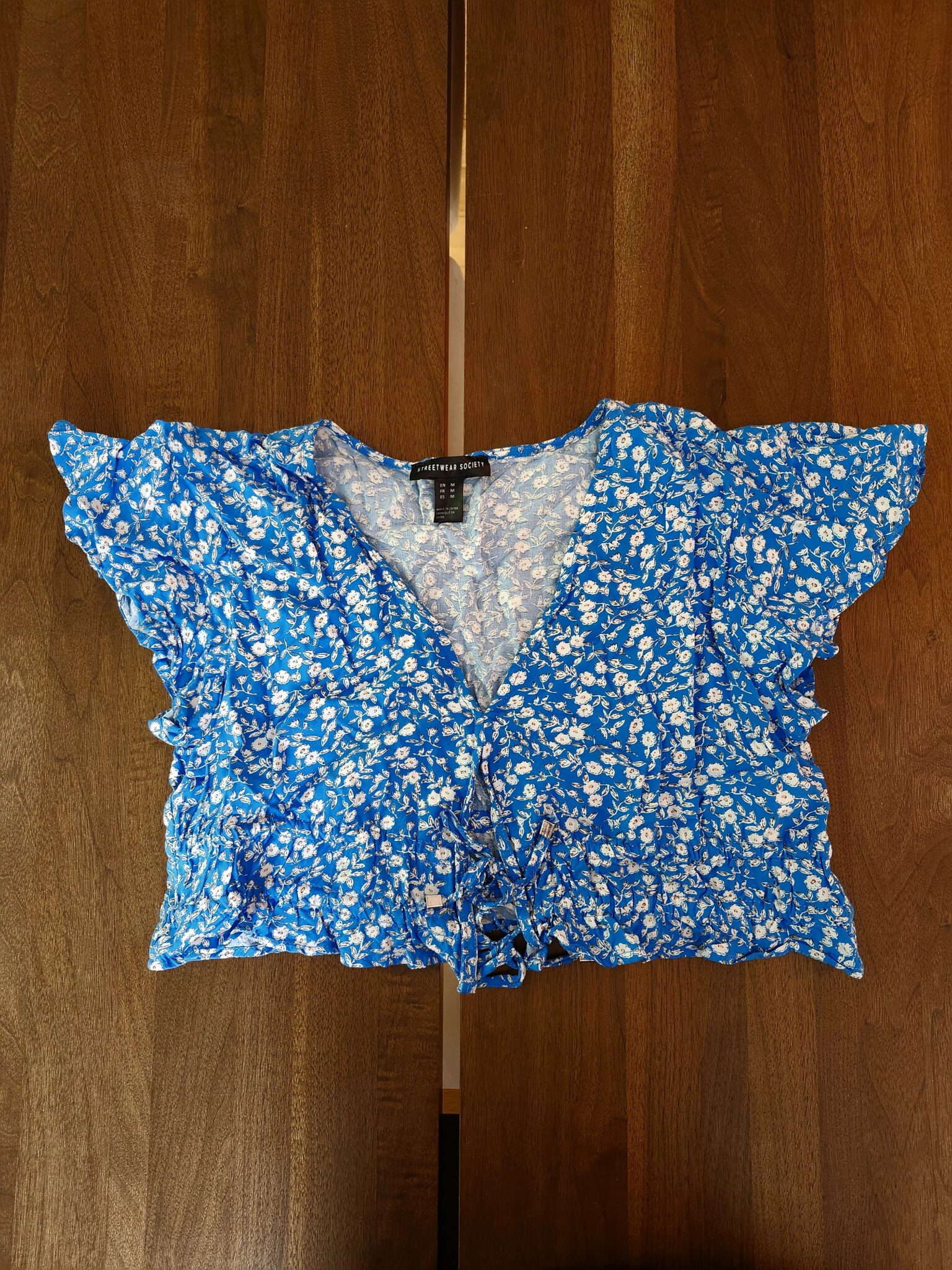 Featured image for Chandail fleurie bleu avec boucles sur le devant