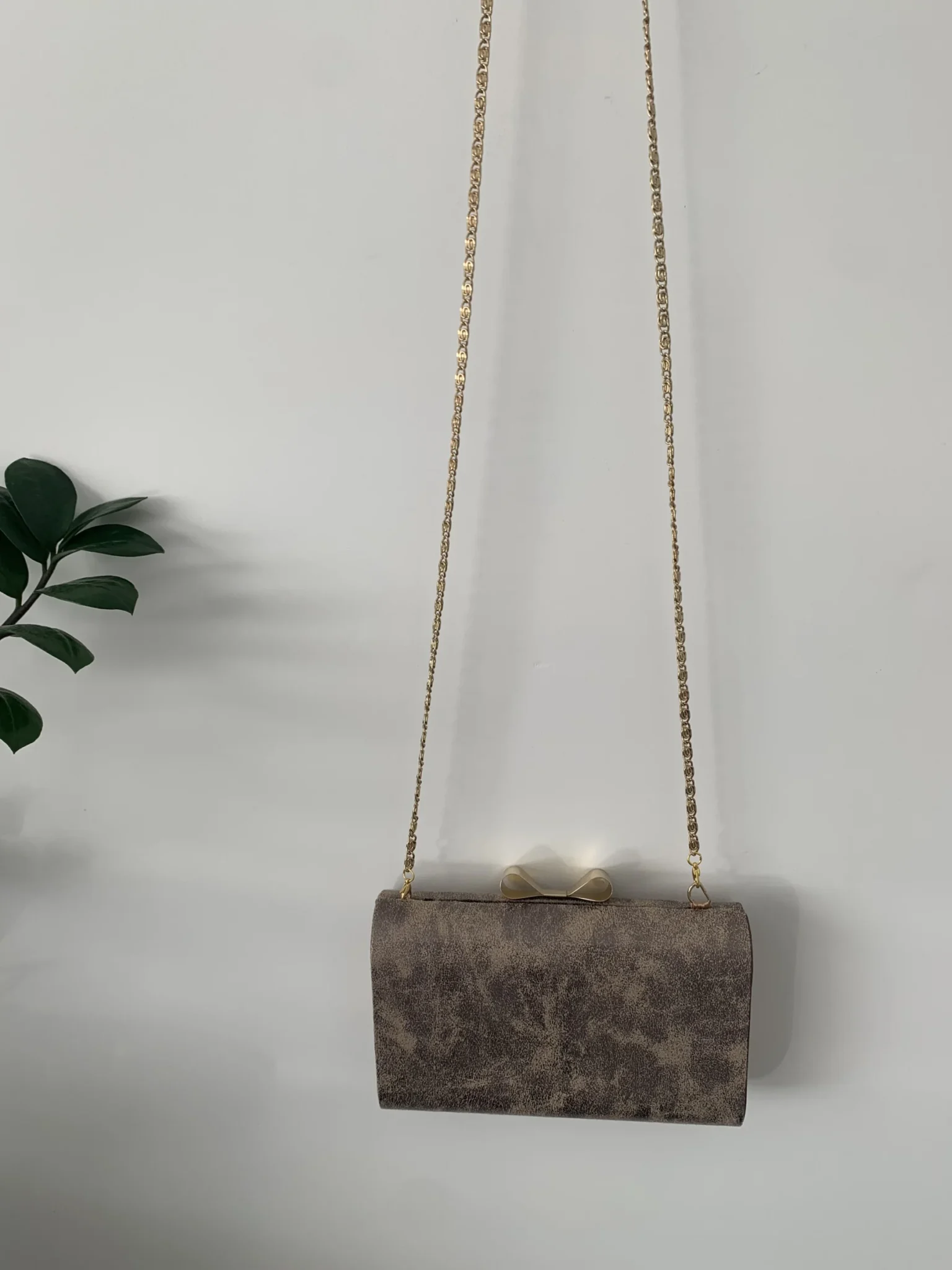 Featured image for Evening clutch bag with gold bow and chain
