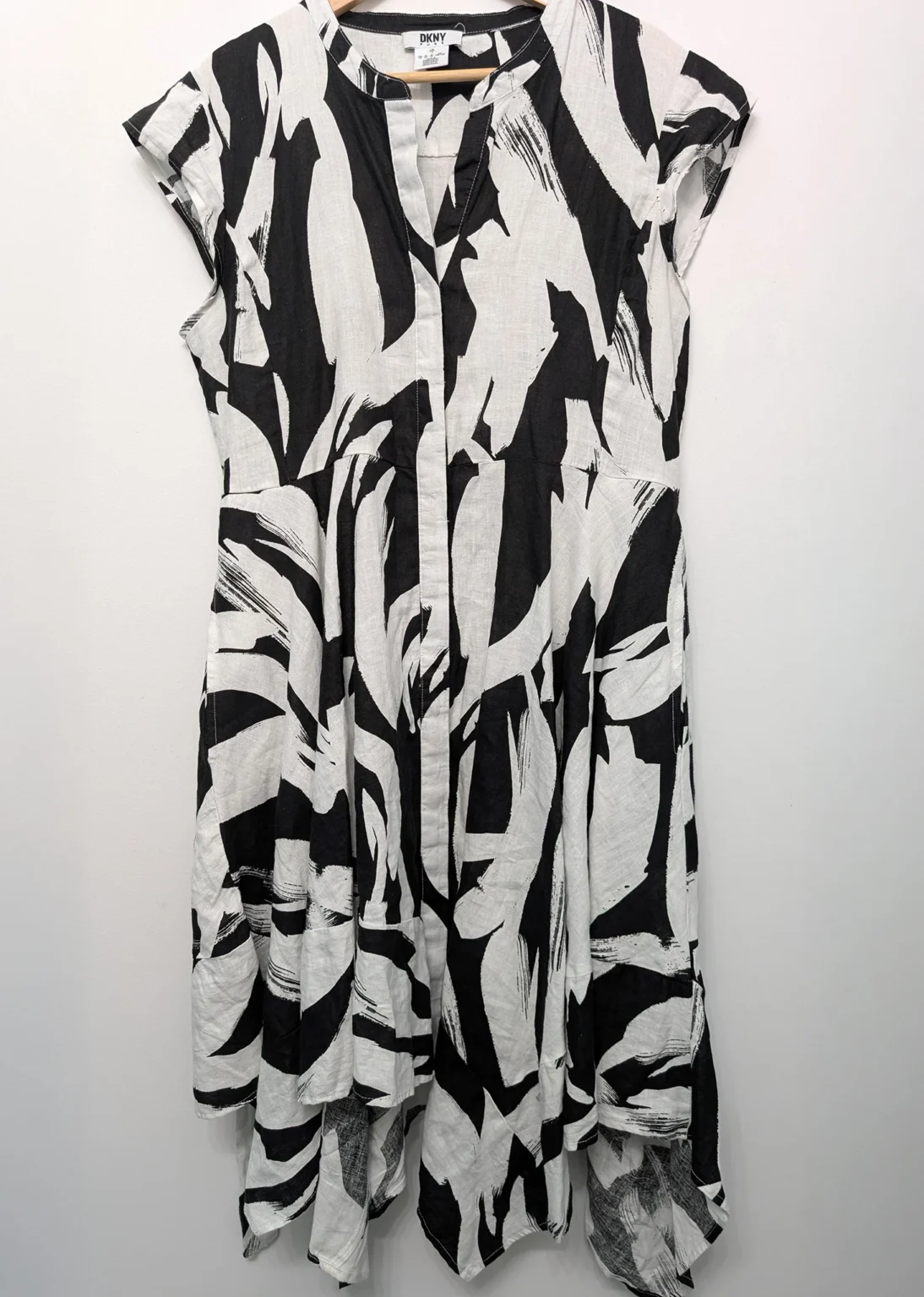 Featured image for Robe blanche DKNY avec motif de fleurs noires.