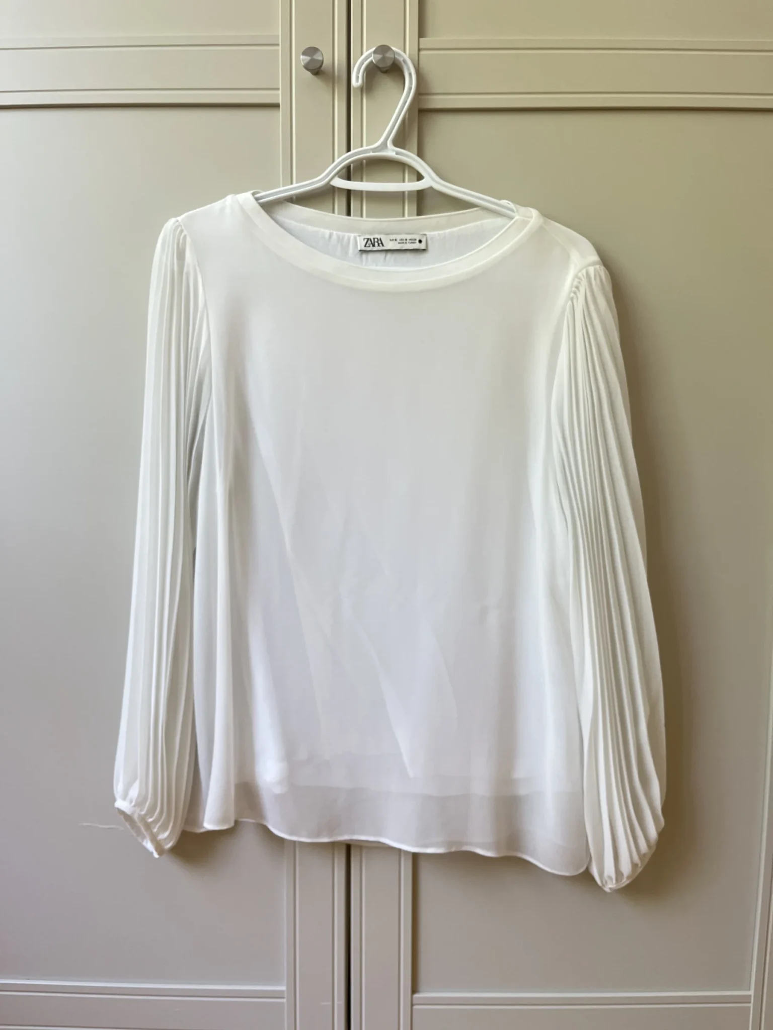 Featured image for White, loose-fitting top with sheer balloon sleeves