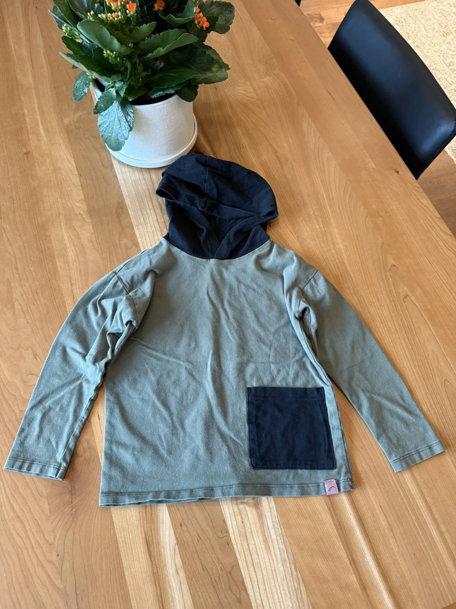 Featured image for Green long-sleeved hooded top
