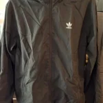 Featured thumbnail for Black hooded windbreaker from Adidas Originals featuring the classic trefoil logo on the chest