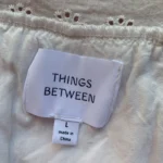 Thumbnail for THINGS BETWEEN – A flirty white babydoll dress with openwork lace and scalloped trim – G
