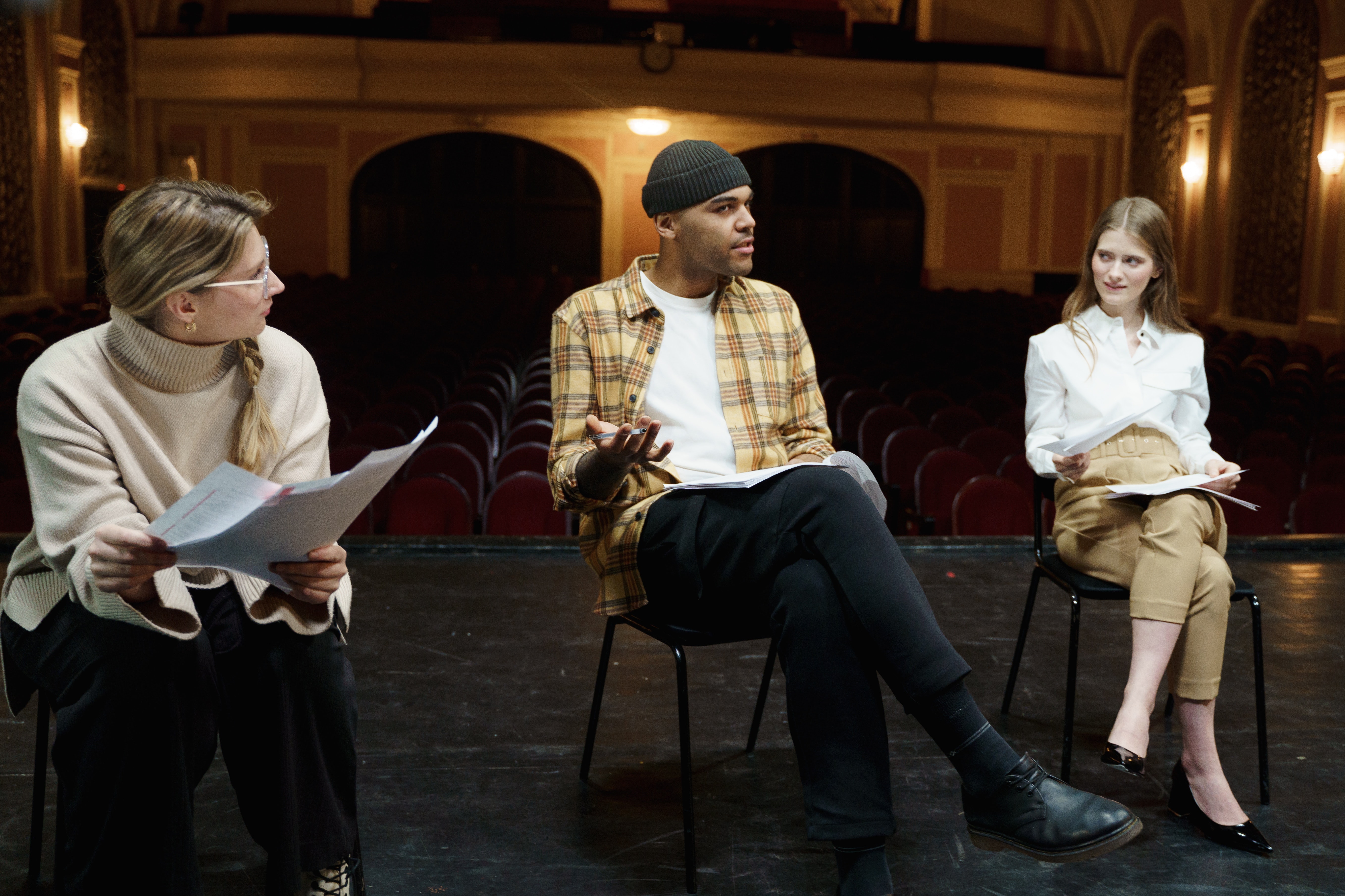 group of people sitting together and discussing a text