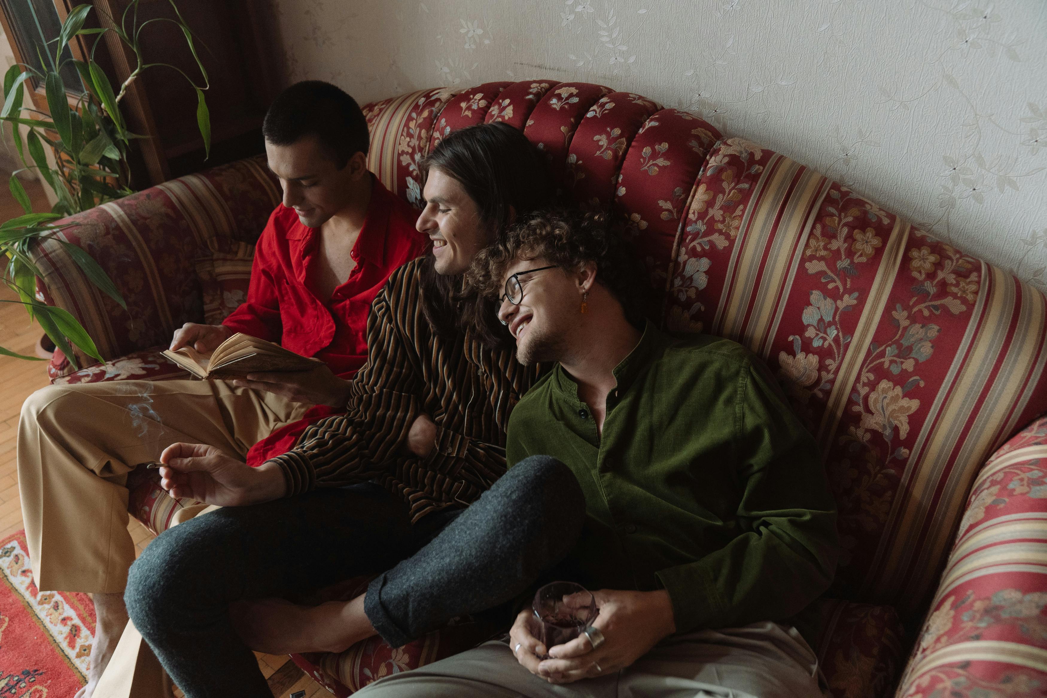 three people reading together on couch