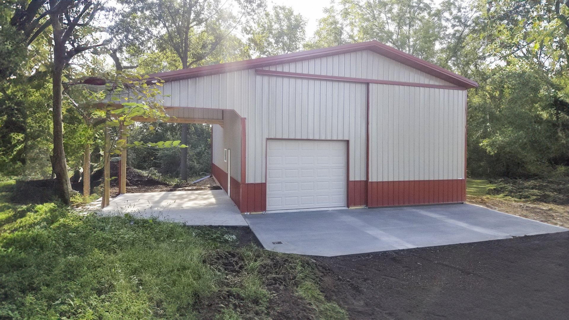 The image shows a post-frame construction building by Built-Mor Buildings. It features a metal exterior with alternating red and white vertical panels. The structure has a large roll-up garage door, indicating its use for storage or as a workshop. The roo