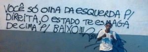 rafael braga vieira posa ao lado de pichacao na porta de presidio