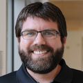 Jonathan Pruneda, Ph.D. (OHSU) Jonathan Pruneda, Ph.D., has short brown hair, a black shirt, and is wearing eye glasses, smiling in a hallway at OHSU research.