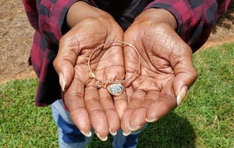 McNeill's 'Healing takes love' bracelet was a gift from her children. Joyce McNeill holds a bracelet her children gave her with the words Healing takes love inscribed on it