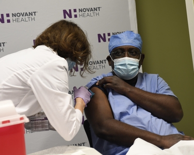 Dr. Samuel Dartey-Hayford, a pulmonary and critical care physician at Novant Health Presbyterian Medical Center, received the hospital's first dose of the vaccine. _DSC3545