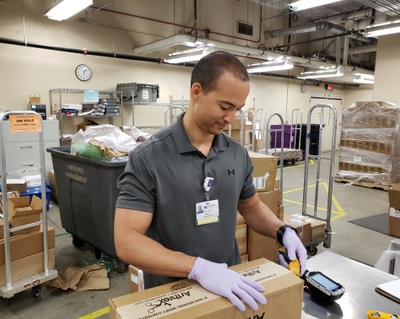 Matt Fortune opens boxes in the supply chain room. Matt Fortune at Novant Health Forsyth Medical Center