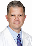 Dr. David Priest Dr. David Priest smiles in white lab coat