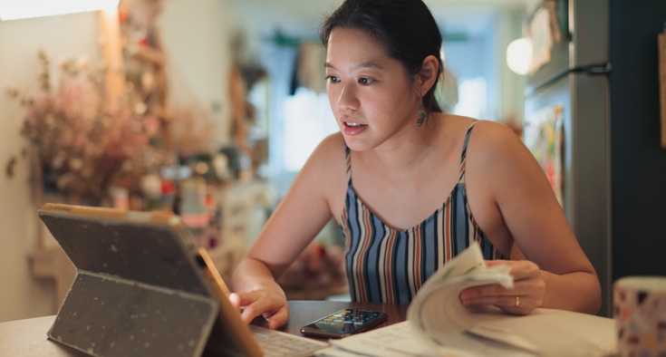 Asian woman looks at computer