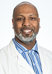 Dr. Card is wearing a lap coat and smiling into the camera