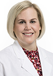 Dr. Catherine Moore smiles in a white lab coat.