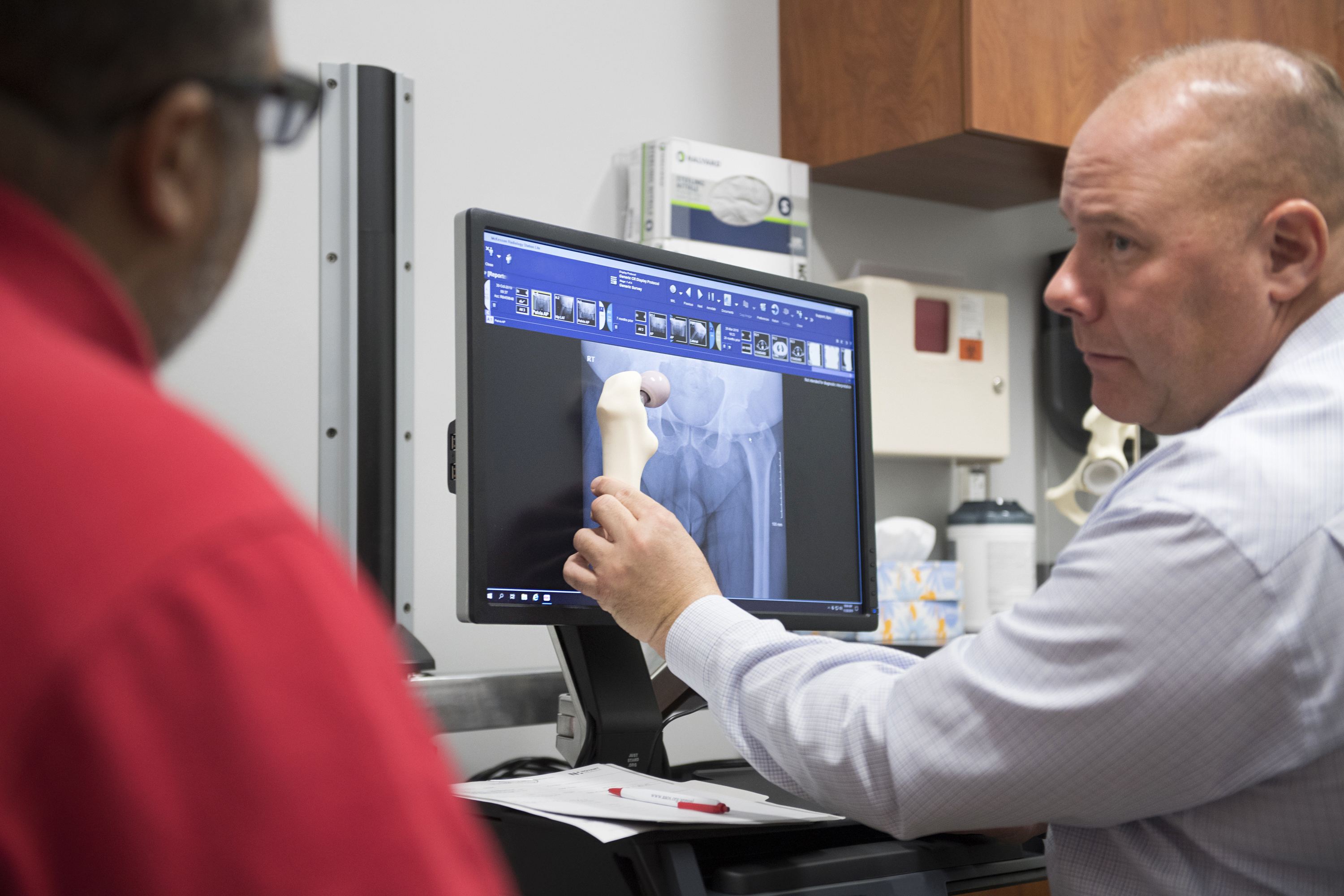 A doctor discusses knee replacement surgery with a patient.