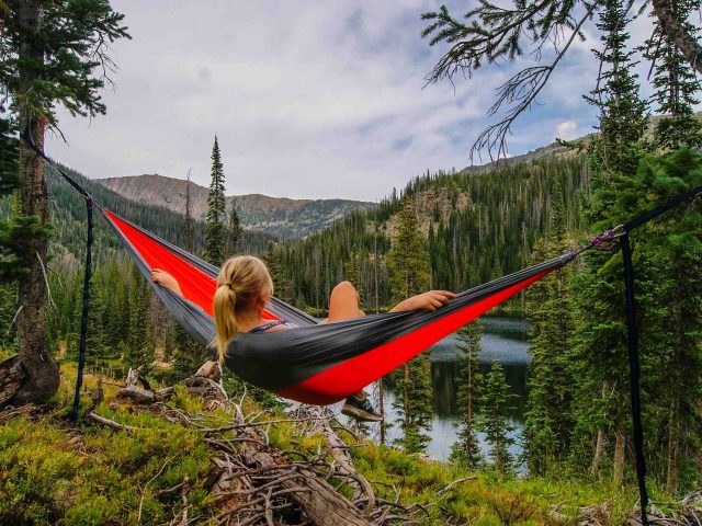 A young woman hammock camping