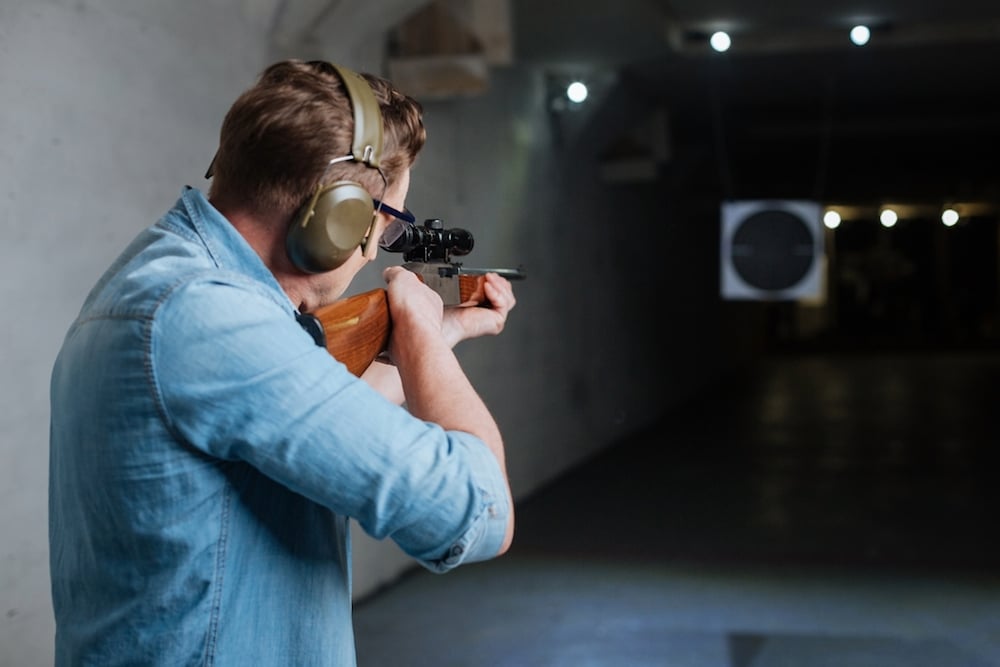 A man shooting a rifle at a gun range