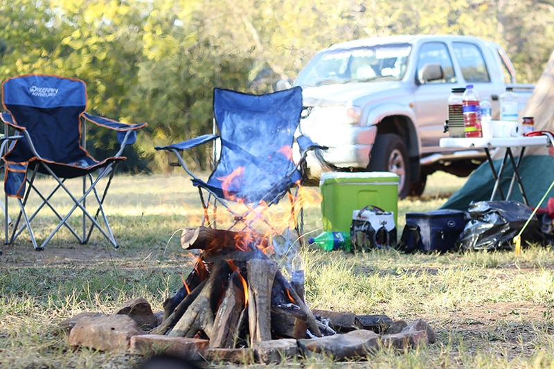 Campfire next to a truck camping setup