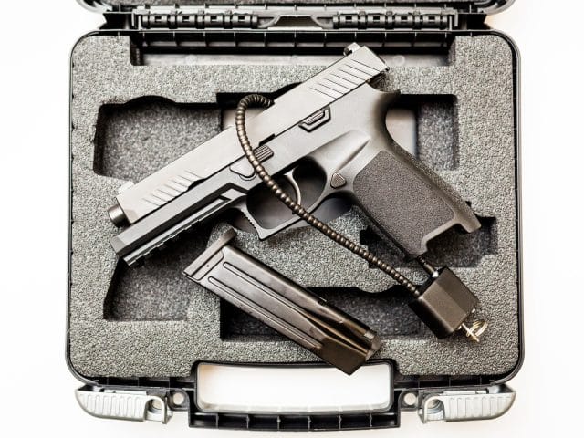 Locked disarmed secured handgun in case white background