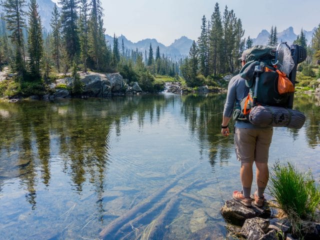 Man backpacking by mountain stream