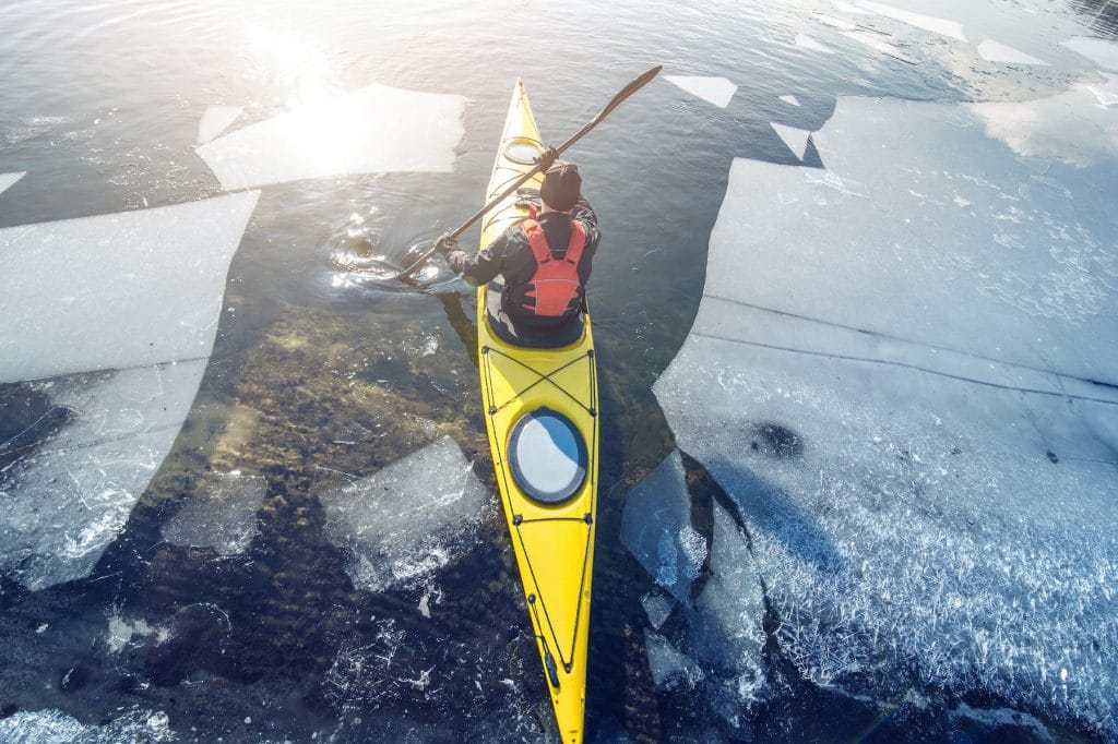 man kayak is on a frozen river