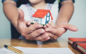 father and daughter holding house in hands