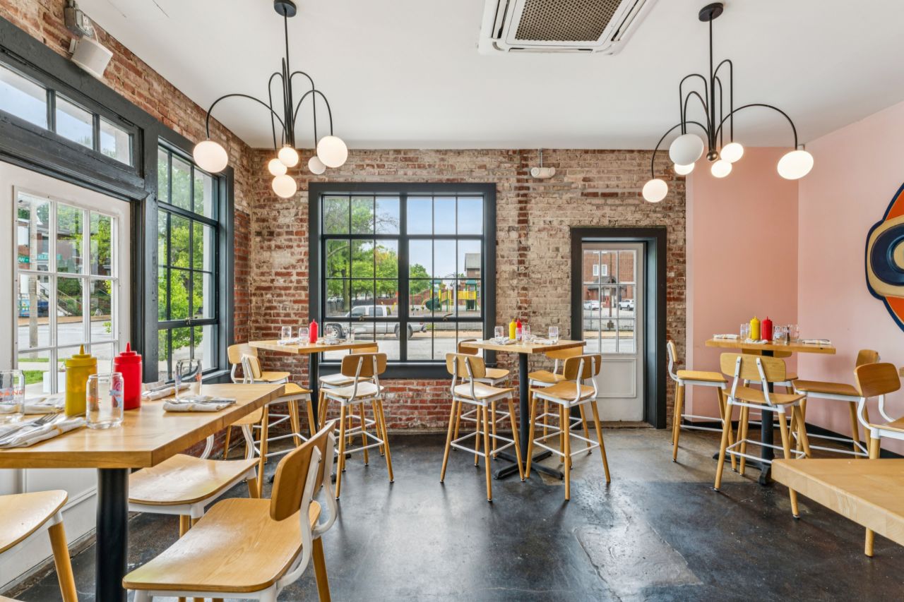 Dining area with brick walls and large windows at restaurant at historic commercial property at 4175 Shaw Blvd in St. Louis Missouri