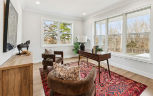 A bright, well-appointed home office with large windows and tree views in a St. Louis move-up home, representing the space and lifestyle that comes with buying up in the St. Louis real estate market.