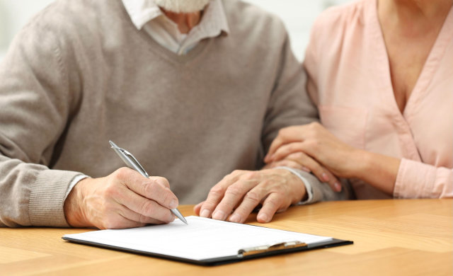 Aging couple signing power of attorney documents