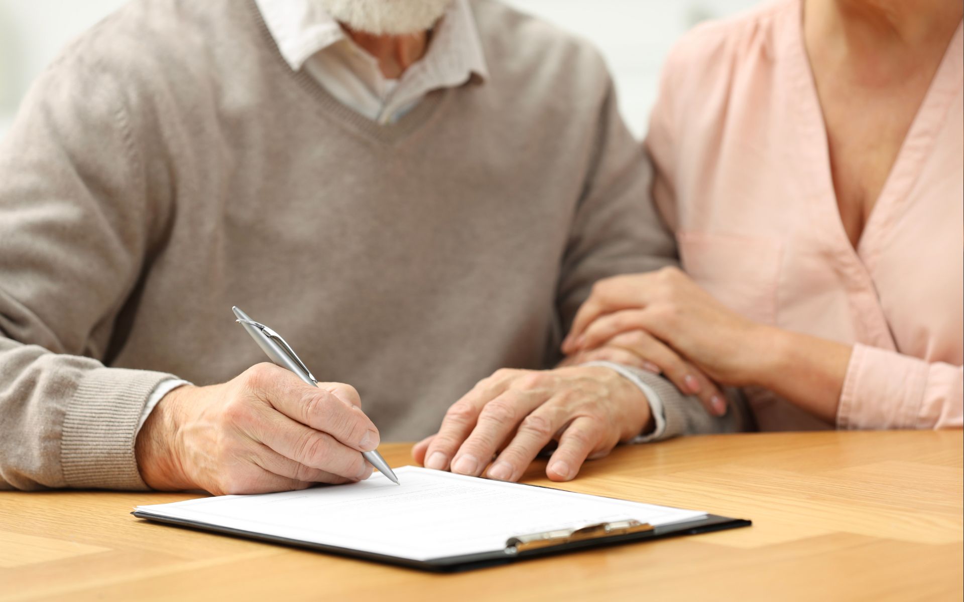 Aging couple signing power of attorney documents