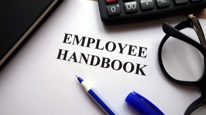 What should be included in termination policies in an employee handbook?