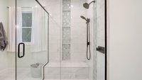 Seafoam tiled shower with custom niche and bench