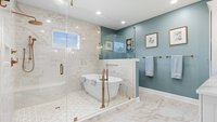 Blue primary bathroom remodel with freestanding tub in tiled shower