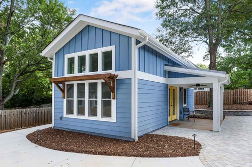 Blue guest house with white trim, yellow door and covered patio