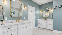 Blue primary bathroom remodel with two vanities and gold hardware