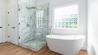 White bathroom remodel with freestanding tub and marble shower