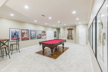Basement with pool table, movie posters and green walls