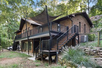 Brick house with wrap brown around deck and screened porch