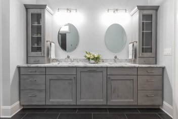 Gray bathroom with double vanity and two oval mirrors