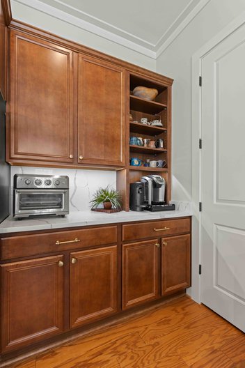 Wood kitchen cabinets with open shelving and white countertop
