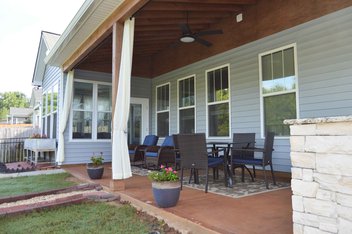 Blue house with covered porch with patio furniture