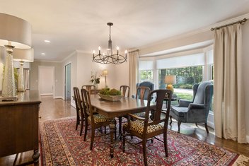 Tan dining room with table, chairs and bay windows