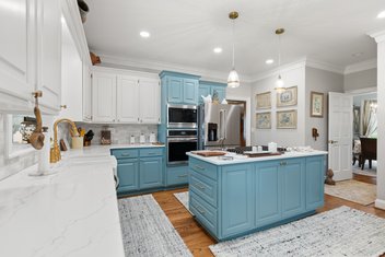 Kitchen remodel with white and blue cabinets and an island in the middle