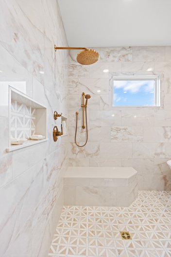 Tiled shower with niche, bench, and window