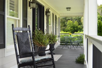 Exterior porch remodel with black rocking chairs